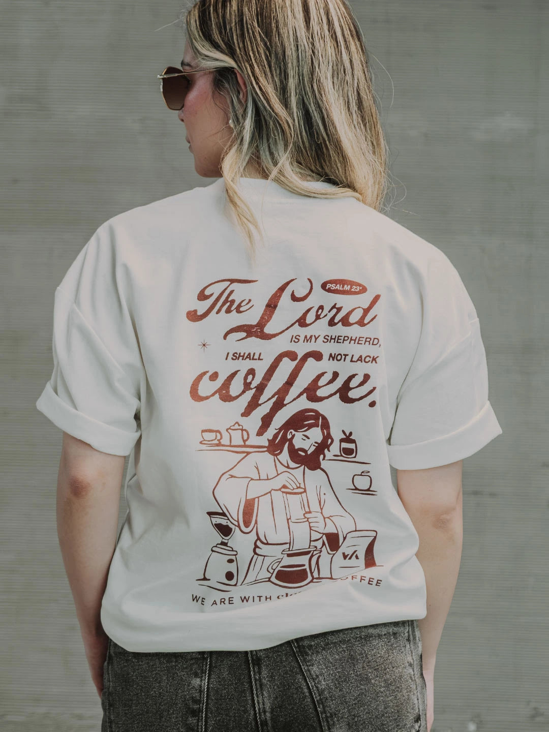 Modelo usando camiseta WE ARE x Clothes Coffee blanca, vista posterior con gráfico