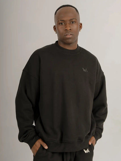 Modelo usando crewneck oversized WE ARE color negro, vista frontal mostrando la silueta, el fit relajado y el logo discreto en el pecho.