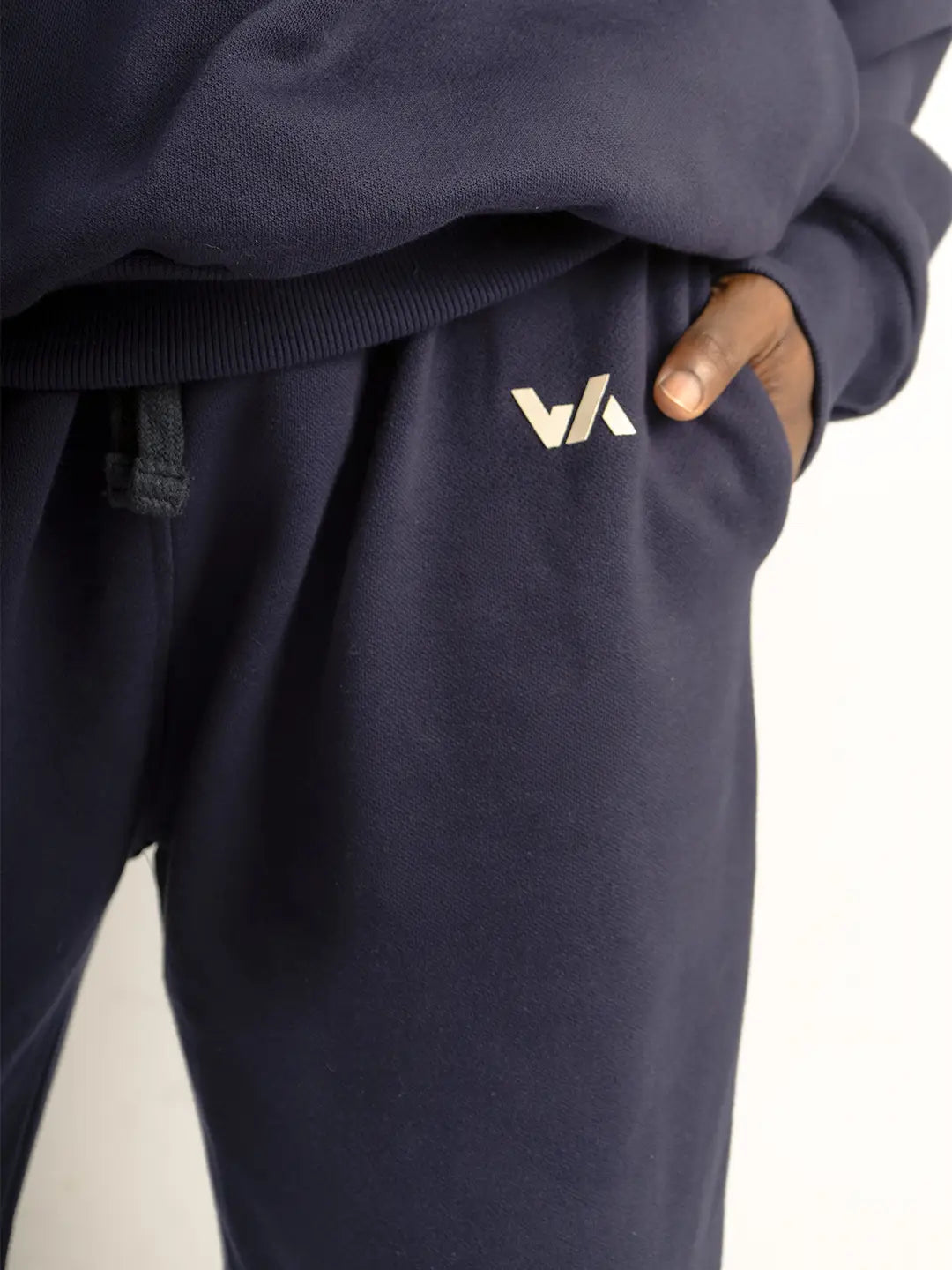 Detalle de jogger WE ARE azul marino con logo estampado y bolsillo