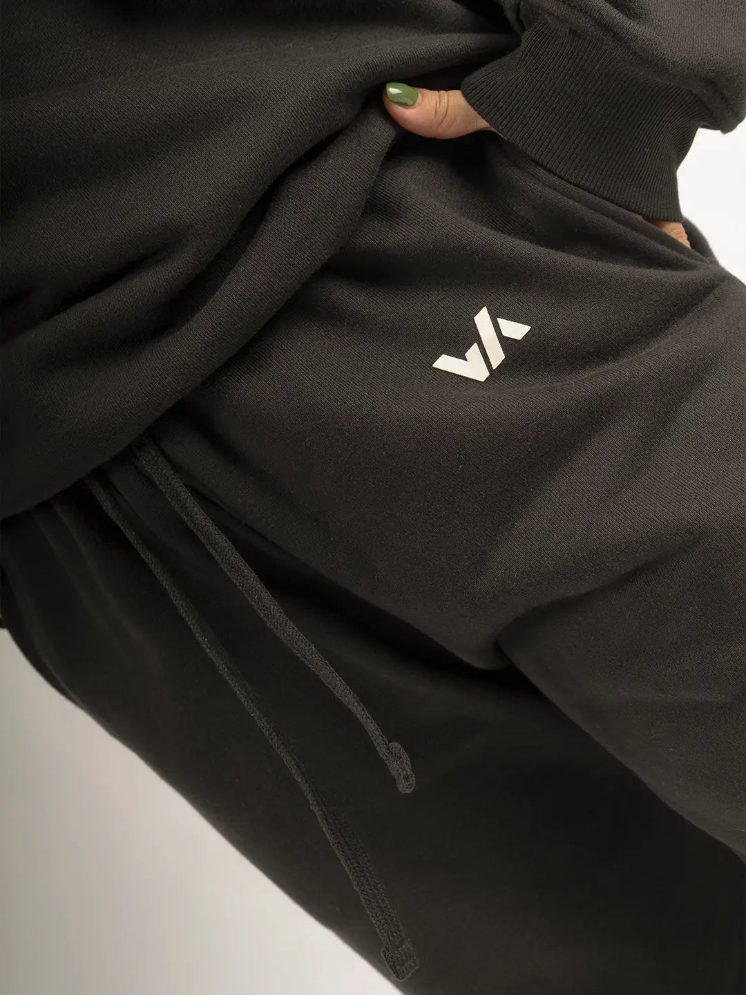 Detalle de jogger WE ARE negro oversized con logo frontal