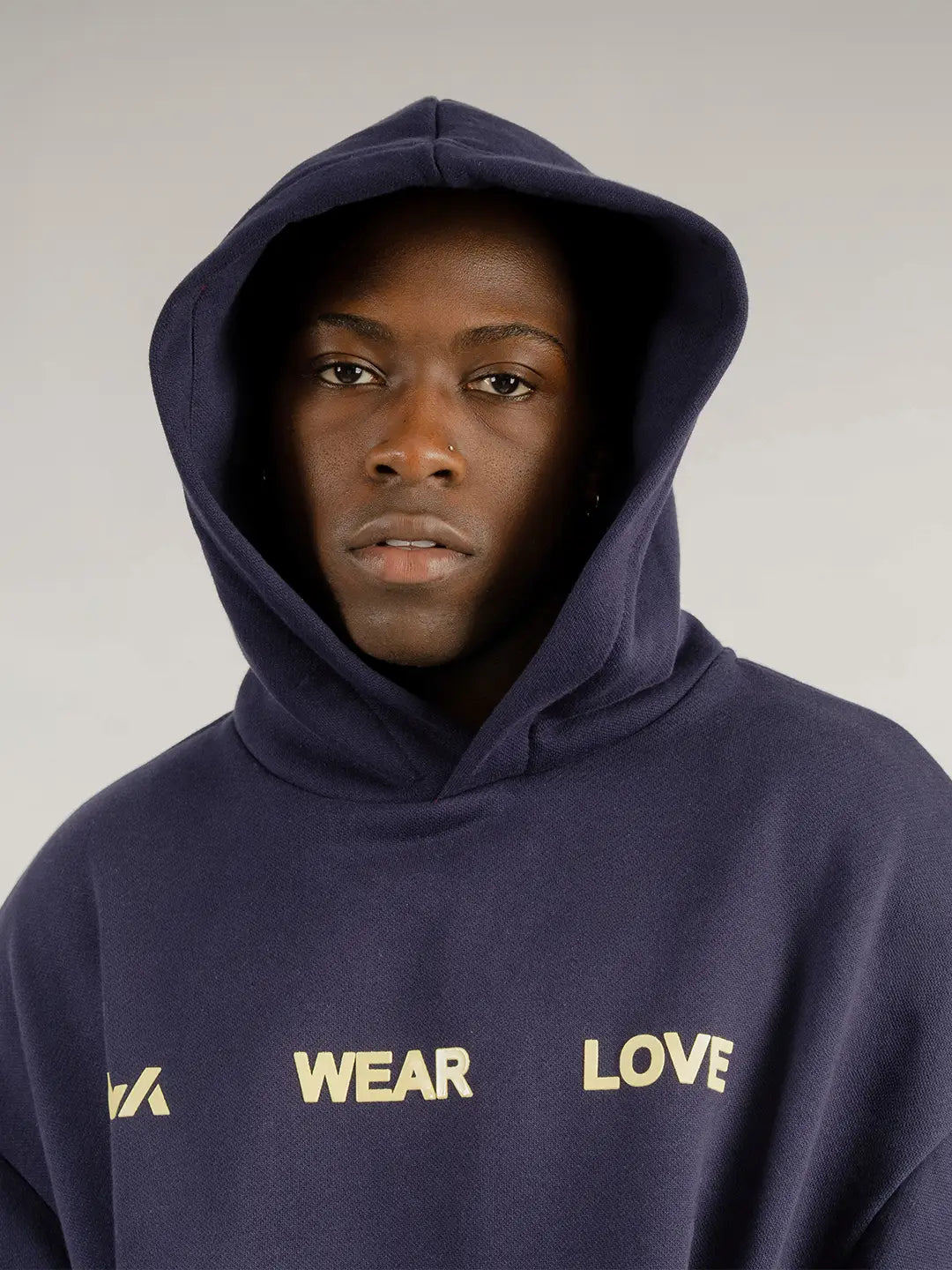 Hoodie oversized WE ARE azul marino, vista frontal con gráfico “WEAR LOVE”.