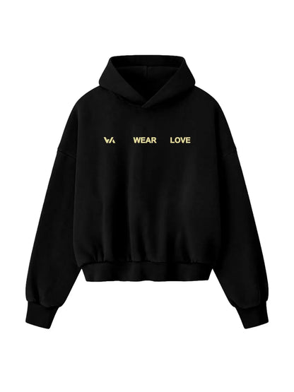 Hoodie oversized WE ARE negro, vista frontal con gráfico “WEAR LOVE”.