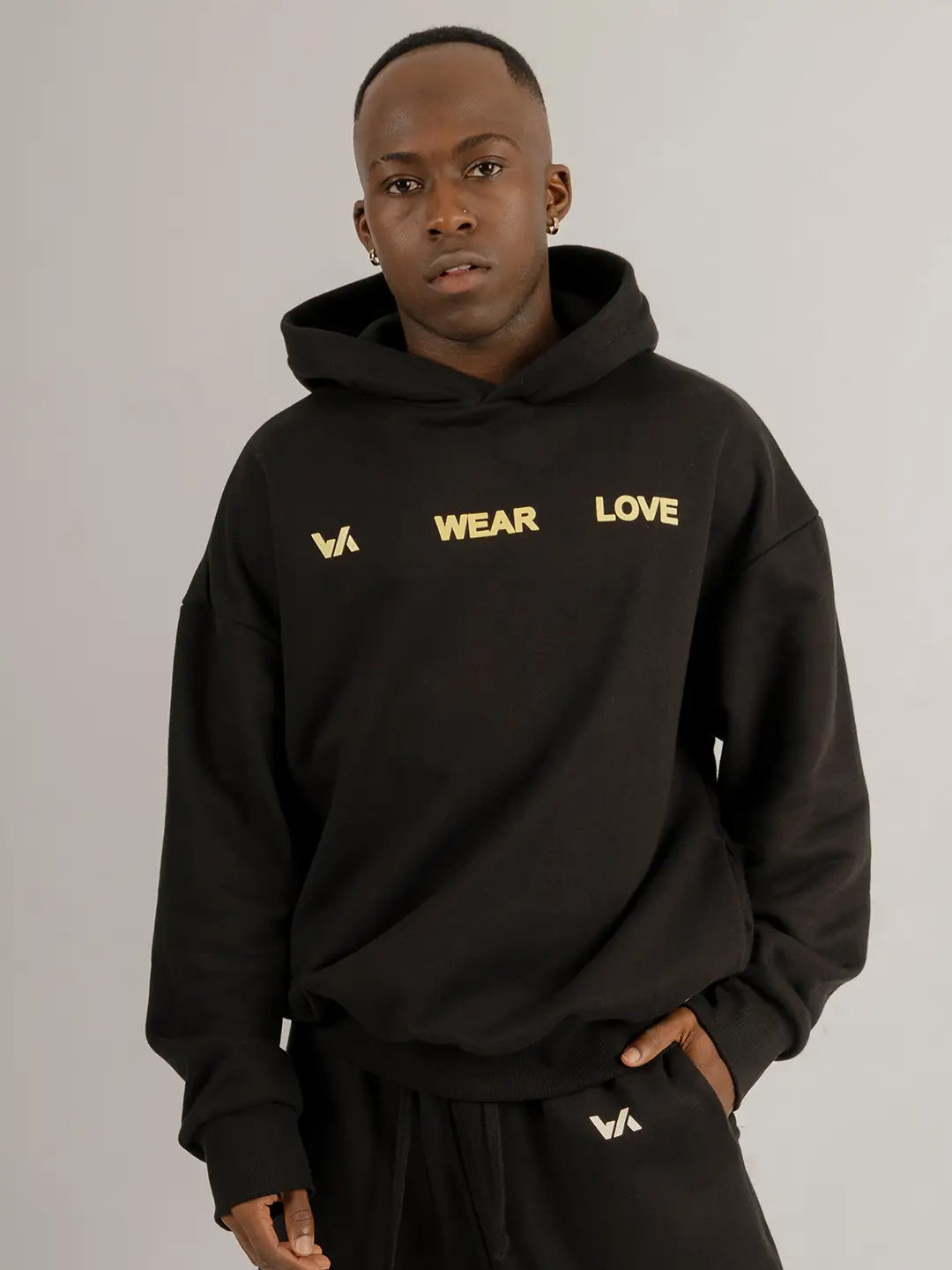 Modelo usando hoodie oversized WE ARE negro con jogger a juego, vista frontal.
