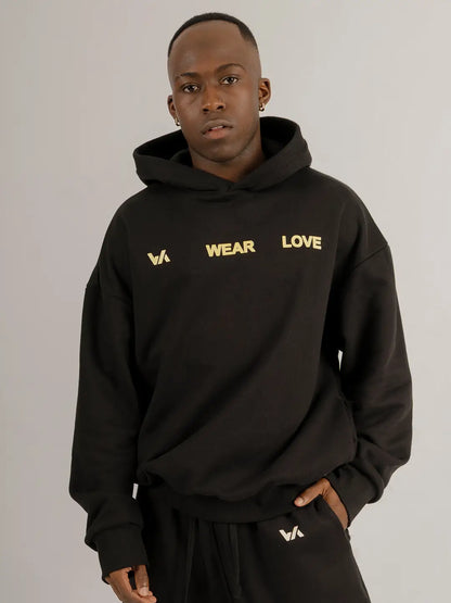 Modelo usando hoodie oversized WE ARE negro con jogger a juego, vista frontal.