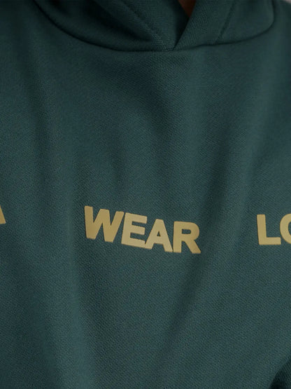 Detalle del estampado frontal “WEAR LOVE” en hoodie verde.